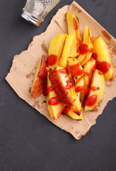 Baked potatoes with ketchup on a white background