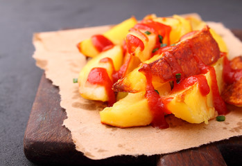 Baked potatoes with ketchup on a white background