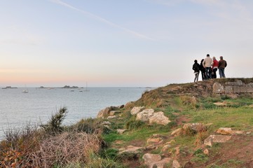Fototapeta na wymiar Un groupe de personnes regarde un beau paysage de mer à Port-Blanc en Bretagne