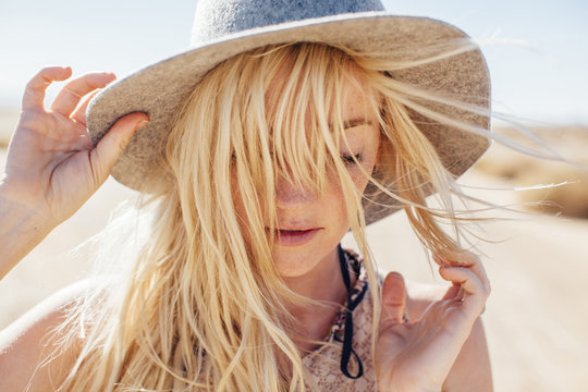 Close-up Of Woman In Sun Hat Enjoying Vacation At Desert On Sunny Day