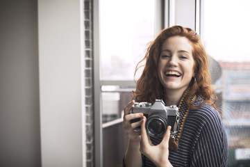 Portrait of happy woman holding camera