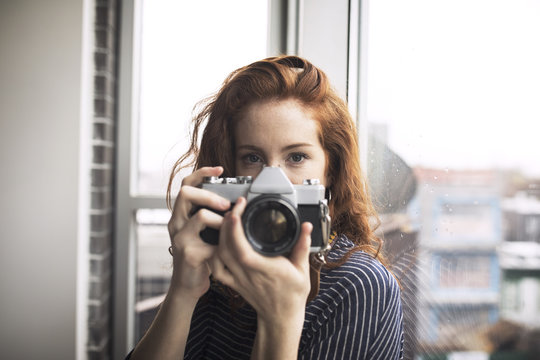 Portrait of woman holding digital camera