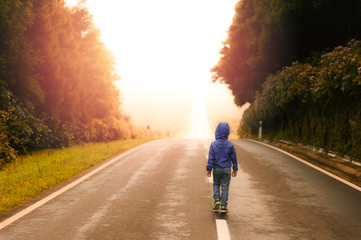 Young Boy Walking on an Empty Road