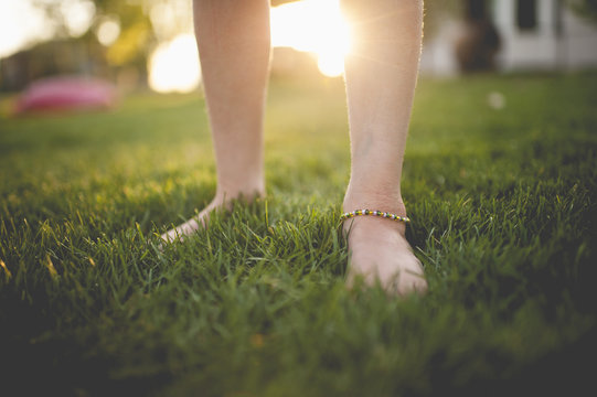 Low section of girl standing in a grassy field