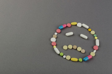 Unhappy smile created from colored pills. Medical concept