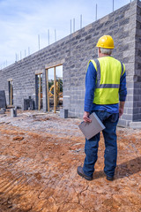 A gray-haired construction supervisor inspects a new retail building job.