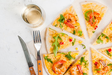 Dietary light vegetarian pizza with vegetables and shrimps prawns, with a glass of white wine on a white stone table copy space top view