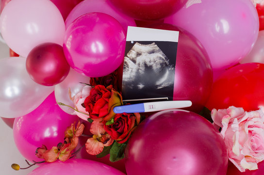 Concept photo ultrasound and pregnancy tests lie in pink balloons