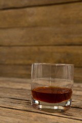 Glass of whisky on wooden table