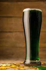 Glass of green beer, chocolate gold coins and 