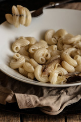 Pasta with chicken in a plate on a wooden table (Elbow macaroni)