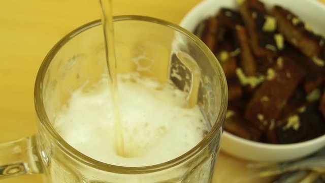 Glass Cup filled with beer on the background of crackers with garlic.