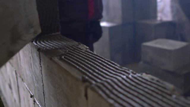 Worker building a wall of aerated concrete blocks