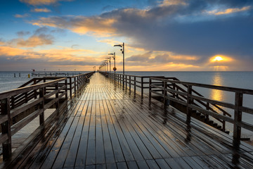 Fototapeta na wymiar Wooden pier in Mechelinki fishing village. Rainy morning on the shore of Baltic Sea. Poland, Europe.