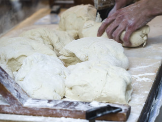 Baker kneading dough. Homemade bread. Hands preparing bread dough on a wooden table. Preparing traditional homemade bread. Man hands kneading fresh dough for making bread