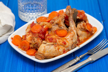 rabbit stew with carrot and tomato on white dish