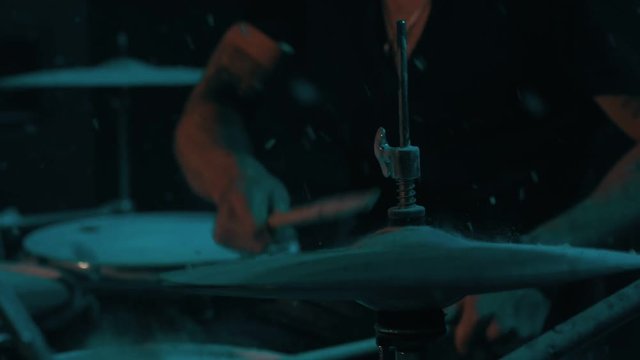 Drummer playing on drum kit. Close up of play drums. Drum playing under snow falling. Drum player kick drum plate. Drummer man playing drums. Man drums music