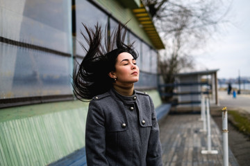 brunette woman outdoor with blowing up hair