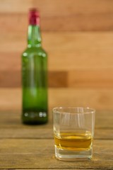 Whiskey bottle and glass kept on table