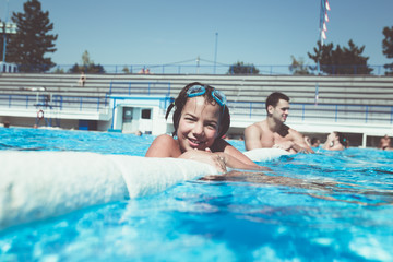 Underwater fun. Cute little girl with goggles swimming underwater and diving in the swimming poll. Sport and leisure.