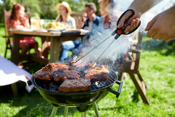 man cooking meat on barbecue grill at summer party - obrazy, fototapety, plakaty