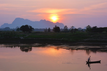 Silhouette of asian fisherman floating in the boat at the sunset in Hpa-An, Myanmar