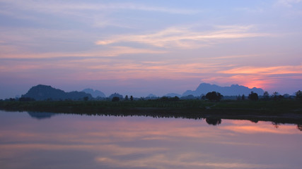 Beautiful tropical sunset over the Salween river with mountains on the background, Myanmar