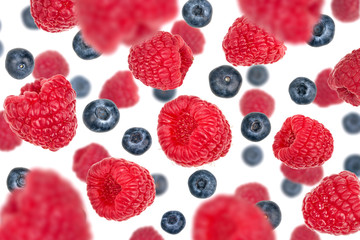 Flying blueberries and raspberries, isolated on white