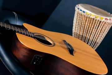 Acoustic guitar with percussion drum in studio on blue backgroun