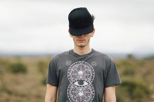 Young man covering his face with a baseball cap