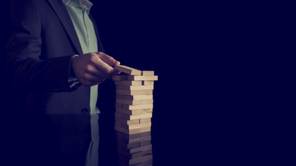Businessman building a tower of stacked blocks