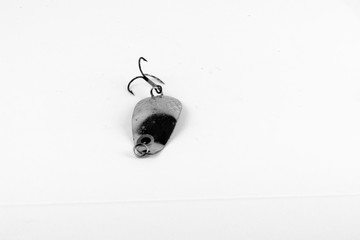 Exhibition of pirated copies of fishing metal spoon baits. Bait for fishing in the shape of a spoon with a hook on a white background. 03/09/2017 Zhitomir.