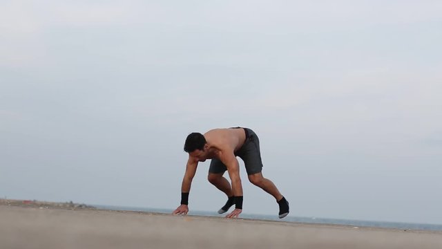 Athletischer Mann macht burpees am Meer