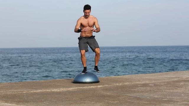 Athletischer Mann trainiert auf Bosu-Plattform