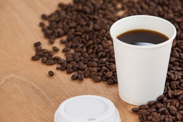 Coffee beans and black coffee in disposable cup