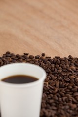 Coffee beans and black coffee in disposable cup