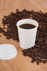 Coffee beans and black coffee in disposable cup