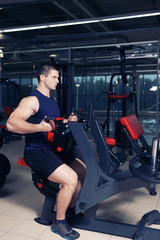 Obraz na płótnie Canvas Young handsome man training in gym