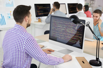 Handsome young programmer working in office
