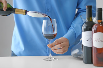 Sommelier pouring red wine into glass