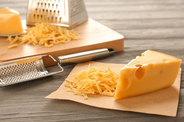 Tasty cheese and graters on wooden table