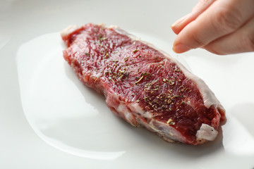 Cooking concept. Hand preparing tasty steak on plate, closeup