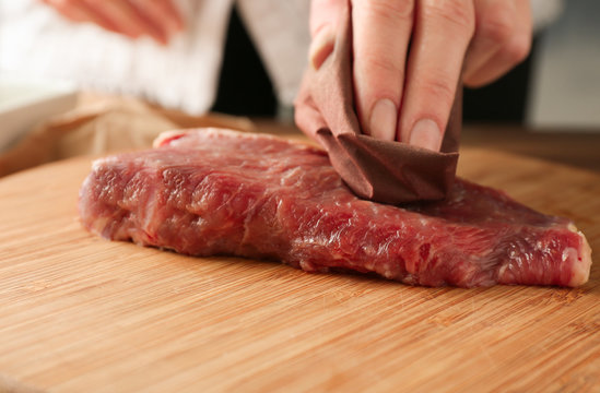 Cooking concept. Hand preparing tasty steak, closeup