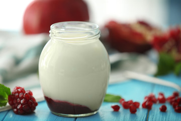 Glass jar with delicious yogurt on wooden table