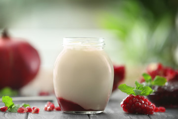 Glass jar with delicious yogurt on wooden table