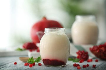 Glass jar with delicious yogurt on wooden table