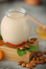 Glass jar with delicious yogurt on board