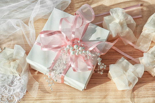 Beautiful gift boxes with bows and bridal veil on light background