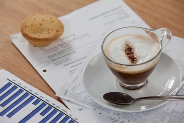 Coffee cup with spoon and documents