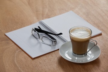 Cup of coffee with spectacles and organizer